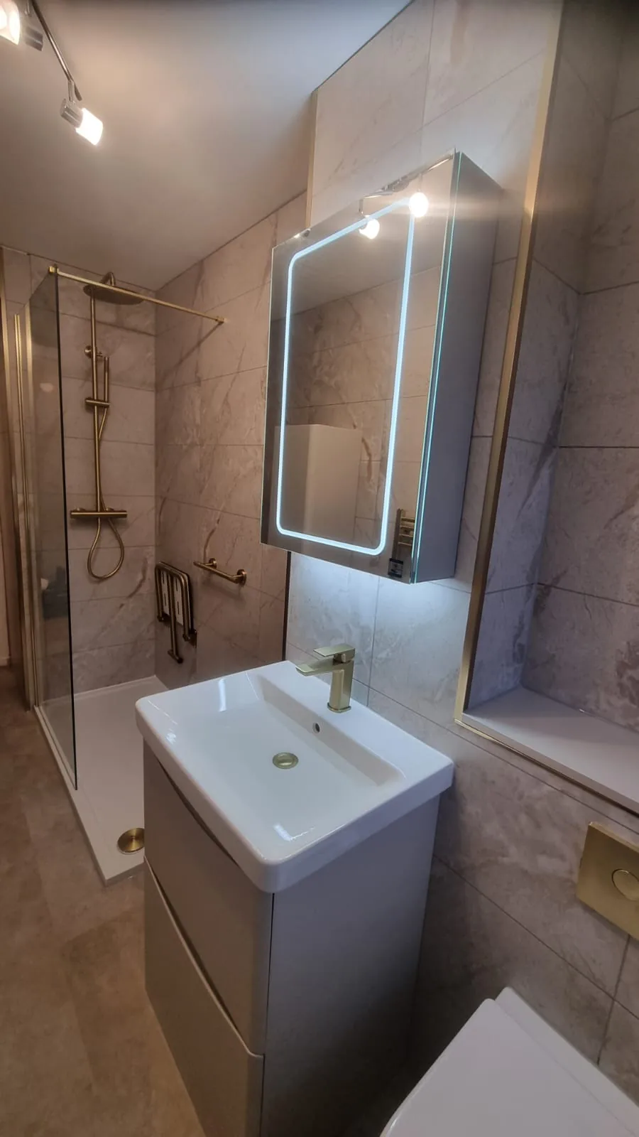 Wall-hung vanity beneath an illuminated mirror
