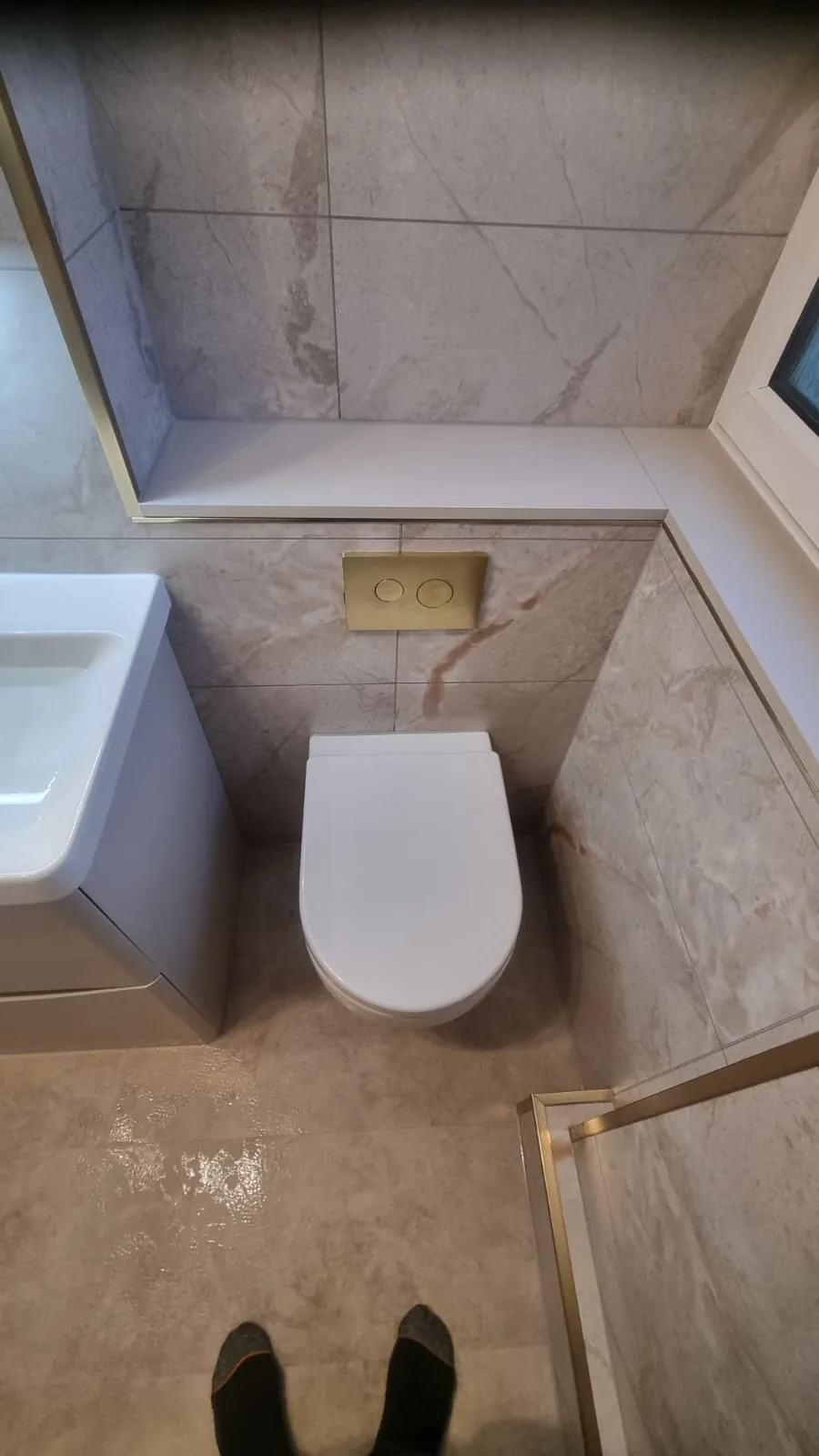 White toilet beneath a frosted bathroom window